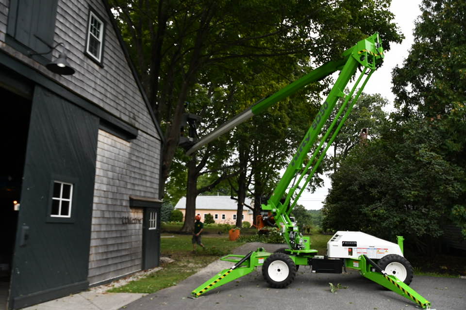 A spider lift in a customer's driveway is used to safely lift arborists into hard to reach trees.